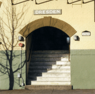 A staircase leading to a tunnel under a building with the word Dresden on it.